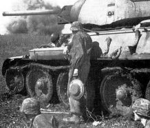 Granaderos Panzer parapetados junto a un tanque T-34 destruido, portando buna mina anticarro Tellermine 43, durante la Batalla de Kursk, verano de 1943.