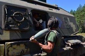 Cargadores de un 2S19 Msta-S de la 26.ª Brigada de Artillería de Ucrania introduciendo munición manualmente por la trampilla del lateral izquierdo.