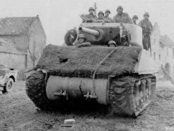 Un M4A3E2 cubierto de sacos terreros con arpillera en el frontal.