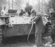 Reparación de un Panzer III que recibió un impacto que penetró el blindaje espaciado de 30 mm y luego dañó el casco. Los mecánicos quitaron la placa para reparar el casco. El hombre en primer plano está usando una amoladora accionada por aire.