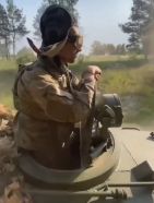 Comandante de un Gvozdika ucraniano asomado en su cúpula mientras avanza a toda velocidad por una pista polvorienta durante la Guerra de Ucrania.
