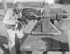 Tripulante de un carro de combate francés realizando tareas de mantenimiento en un cañón corto de 37 mm SA 18 desmontado de la torreta y depositado sobre un soporte apropiado para estas labores.