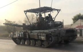 Modificación de campo de un T-64BV con blindaje de rejillas añadido en los costados de la torre, en la parte trasera del motor y con una cubierta cenital antidron.[2]