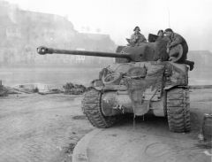 Un Sherman Firefly con varios elementos en el frontal como trozos de cadenas y ruedas de repuesto.
