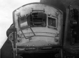 Cubierta del puesto del conductor abierta y vista desde el interior, se pueden observar los cristales blindados del visor.