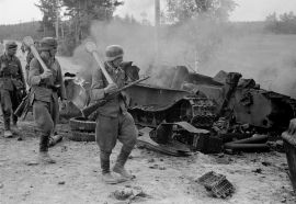 Soldados finlandeses del 12º Regimiento de Infantería armados con Panzerfaust pasando por delante de un T-34 soviético destruido por un cañón de asalto alemán durante la Batalla de Tali-Ihantala en julio de 1944.