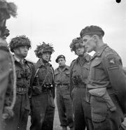 El comandante de la 3.ª Brigada Paracaidista, James Hill, hablando con hombres del 1.er Batallón Paracaidista Canadiense. El comandante del batallón, Jeff Nicklin, se encuentra al lado de Hill. Diciembre de 1943.
